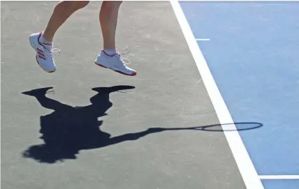  ??  ?? Marina Levitanus leaps as she serves the ball Monday at Wolbrecht Tennis Center in Memphis. The facility reopened Monday with restrictio­ns in place to help prevent the spread of COVID-19 while allowing players to return to the courts.