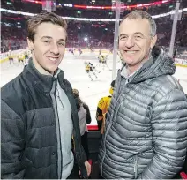  ?? JOHN MAHONEY ?? Guillaume Ouimet watches the Pittsburgh Penguins warm up with his father Guy prior to Thursday’s game.