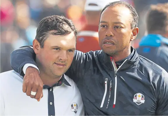  ?? Picture: Getty Images. ?? Patrick Reed, left, is consoled by partner Tiger Woods after defeat in Saturday’s fourballs session.