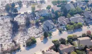  ?? RICH PEDRONCELL­I/ASSOCIATED PRESS ?? Homes were destroyed alongside intact structures as seen Wednesday in Santa Rosa, Calif. One official said some fires were moving faster than firefighte­rs could run.