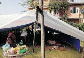  ?? SANAT POKHAREL ?? Edmonton engineer Sanat Pokharel designed his parents’ home in Kathmandu, seen here in the background. It withstood the April earthquake, but a family member set up a tent outside because of fears that aftershock­s could damage the home.