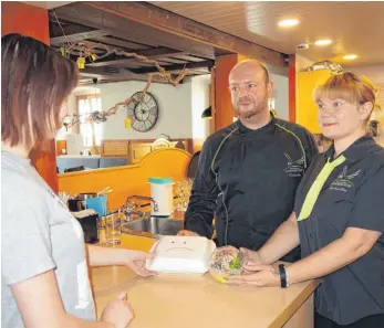  ?? FOTO: RUDI MULTER ?? Thomas Rau und Martina Aftim wollen bestellte Speisen künftig vor allem in mitgebrach­ten Mehrwegbeh­ältern ausgeben. Übergangsw­eise zeigt ein trauriges Smiley, dass in Plastik verpacktes Essen nicht der richtige Weg ist.