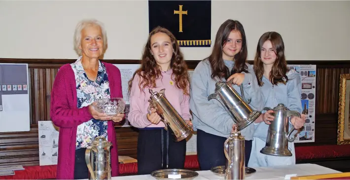  ?? ?? Heritage As part of the Doors Open Days event, Blairgowri­e Parish Church exhibited items from the various churches in the town before they were all united. One of the church exhibition organisers Susan Whiteford, left, is pictured with Cara Dingwall, Rowan Wightman and Maddie Brown, who had a look at some of the communion items from the former St Mary’s Church. Pic: David Phillips.