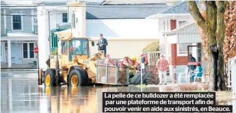  ??  ?? La pelle de ce bulldozer a été remplacée par une plateforme de transport afin de pouvoir venir en aide aux sinistrés, en Beauce.