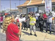  ?? AP ?? Gennice Mackey leads a chant of “Save the Raise!” outside a McDonald’s in St. Louis. A Missouri law that takes effect Monday prohibits cities from having a higher minimum wage than the state’s $7.70 per hour.