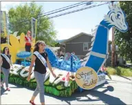  ??  ?? The City of Kelowna’s refurbishe­d Ogopogo float, left, made its first Rutland May Days appearance on Saturday while the Kelowna Pipe Band Society banged out some tunes.
