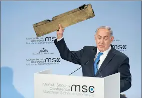  ?? AP/LENNART PREISS ?? Israeli Prime Minister Benjamin Netanyahu holds what he claimed was a piece of a downed Iranian drone Sunday and directly addresses Iran’s foreign minister, Mohammad Javad Xarif, while speaking at the Munich Security Conference.