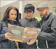  ?? CAPE BRETON POST PHOTO ?? Trevor Boudreau, centre, looks over some informatio­n with his mother Raylene Stephens and stepfather Bernie MacIntosh during CBU 101 at the Cape Breton University’s Verschuren Centre on Tuesday night. The event for high school students and their parents included a campus tour and informatio­n on financial aid and scholarshi­ps.