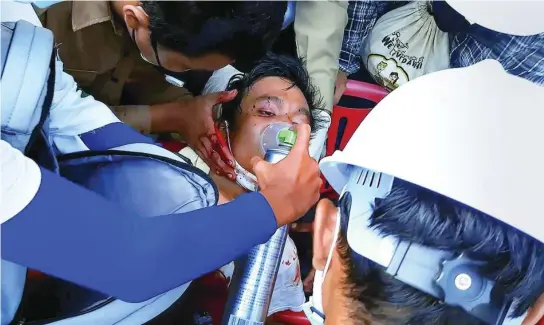  ??  ?? Un joven herido de bala en el pecho es atendido en una calle de Dawei, Myanmar, ayer