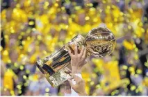  ?? MARCIO JOSE SANCHEZ/ASSOCIATED PRESS ?? Golden State’s JaVale McGee holds up the Larry O’Brien championsh­ip trophy after the Warriors defeated the Cavaliers 129-120 on Monday night.