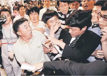  ??  ?? Family members of passengers onboard the sunken ferry Sewol struggle with a security officer (right) while attempting to attend the murder trial of the captain and crew from the sunken ferry Sewol at the Gwangju District Court in the southweste­rn South...