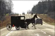  ?? HEATHER AINSWORTH / THE NEW YORK TIMES ?? A buggy turns onto Route 14A in Penn Yan, N.Y. A surge in the population of Amish and Mennonites in northern New York has produced more buggies on the state’s roads, which has led to more accidents with cars.