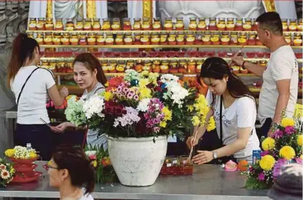  ?? PIC BY EIZAIRI SHAMSUDIN ?? Devotees performing religious rituals in conjunctio­n with Wesak Day at the Thai Buddhist Chetawan Temple in Petaling Jaya yesterday.