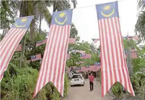  ?? PIC BY SHARUL HAFIZ ZAM ?? Padi farmer Mohd Salleh Md Lazim spent RM500 on some 200 Jalur Gemilang to decorate his house in Kampung Pinang, Simpang Empat, Kedah.