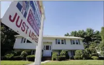  ?? AP FILE PHOTO ?? A for sale sign hangs in front of a house.