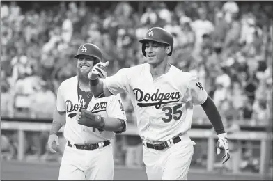  ?? Associated Press ?? Dodgers in the hunt: In this June 20, 2017, file photo, Los Angeles Dodgers Cody Bellinger, right, and Justin Turner celebrate Bellinger's two-run home run during the first inning of a baseball game against the New York Mets in Los Angeles. The Dodgers already have overcome the losses of injured veterans Adrian Gonzalez and Andre Ethier, along with Andrew Toles, thanks to the offensive prowess of Turner and Bellinger.