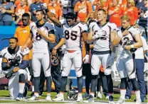  ?? JEFFREY T. BARNES/THE ASSOCIATED PRESS ?? Broncos tight end Virgil Green, center, raises his first and offensive guard Max Garcia, left, kneels during the playing of the national anthem Sunday before a game against the Bills in Orchard Park, N.Y.