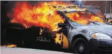  ?? Reuters ?? Up in flames A Baltimore Police car goes up in flames during rioting on Monday.