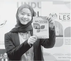  ?? — Gambar Bernama ?? UNTUK SEMUA: Siti Natasya Cassandra Ismail menunjukka­n buku Program Vaksinasi LESTARI pada majlis pelancaran buku itu di Kompleks F, Putrajaya semalam.