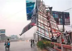  ??  ?? An advertisin­g billboard is torn apart due to heavy winds in
■ Karachi on Friday.