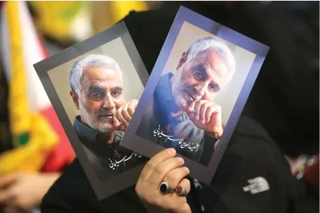  ?? (Aziz Taher/Reuters) ?? A SUPPORTER of Hezbollah leader Sayyed Hassan Nasrallah carries pictures of the late Iranian Quds Force commander Qassem Soleimani, during a rally in Beirut on February 16.