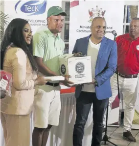  ?? ?? Zandre Roye (second left) is presented with the Trinidad and Tobago Open Golf Championsh­ip prize by Trinidad & Tobago’s Sports Minister Shamfa Cudjoe (left) and Shakka Subero (second right), representi­ng sponsor National Lotteries and Control Board, while Trinidad & Tobago Golf Associatio­n President Wayne Baptiste looks on.