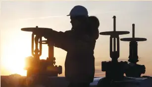  ?? (Sergei Karpukhin/Reuters) ?? A WORKER CHECKS the valve of an oil pipe at the Lukoil-owned Imilorskoy­e oil field near Kogalym, Russia, in January.