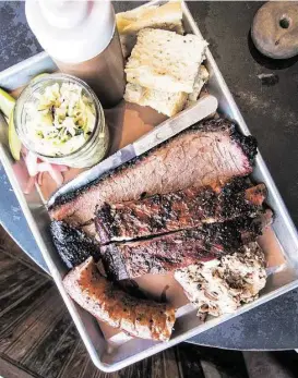  ?? J.C. Reid photos ?? The “Holy Trinity Plate” — brisket, ribs, sausage — at Freedmen’s Bar in Austin.