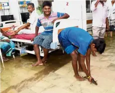  ?? — AFP ?? Unwanted visitor: A boy catching a fish inside a waterlogge­d room at Nalanda Medical College hospital in Patna.