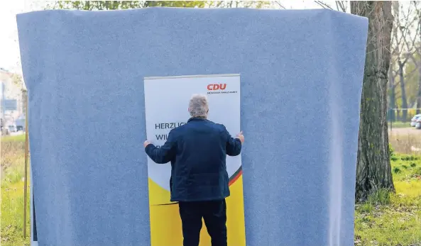  ?? FOTO: KLAUS-DIETMAR GABBERT/DPA ?? Ein Helfer stellt in Sachsen-Anhalt ein Wahlplakat der CDU vor ein weiteres, noch verhülltes Wahlplakat.