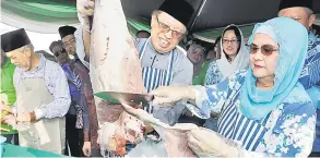  ?? — Gambar Chimon Upon ?? BERSAMA: Abang Johari membantu Juma’ani melapah daging korban untuk diagihkan kepada warga kerja Wisma Bapa Malaysia dan Jabatan Ketua Menteri semalam.
