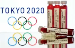  ?? (Reuters) ?? FAKE BLOOD iS seen in test tubes labeled with coronaviru­s disease (COVID-19) in front of a displayed Tokyo 2020 Olympics logo.
