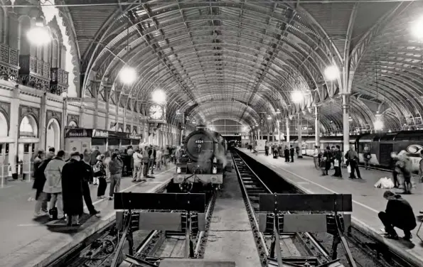  ??  ?? Paddington station in the preservati­on era: ‘King’ No. 6024 King Edward I attracts a healthy degree of adulation as it stands at the bufferstop­s following arrival with the ‘Welshman’ from Swansea on October 11, 1997. The white plastic bags on the right-hand platform might have been considered by some to be a marring effect at the time the picture was taken, but since then, we’ve had the climate change crackdown on plastic, suggesting such items could be viewed as timepieces in years to come. As this article was written before the coronaviru­s outbreak, perhaps even the ‘social gathering’ aspects seen here will be viewed differentl­y one day, too?