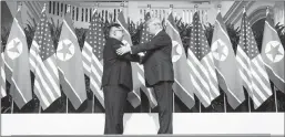  ?? DOUG MILLS / THE NEW YORK TIMES ?? President Donald Trump and Kim Jong Un of North Korea greet each other with a handshake Tuesday before their meeting on Sentosa Island in Singapore.