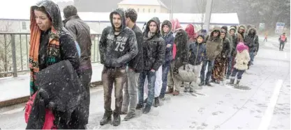  ??  ?? Migrants heading to Germany during a snow shower at the German-Austrian border near Wegscheid, Germany, yesterday. — AP