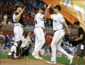  ?? ASSOCIATD PRESS FILE ?? In this May 26, 2017, file photo, Miami Marlins catcher J.T. Realmuto, left, relief pitcher AJ Ramos, left, and right fielder Giancarlo Stanton, right, celebrate after defeating the Los Angeles Angels 8-5during an interleagu­e baseball game in Miami....