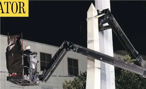  ?? GERALD HERBERT / THE ASSOCIATED PRESS ?? Workers in New Orleans dismantle the Liberty Place monument, which commemorat­es whites who tried to topple a biracial post-Civil War government. It was removed overnight in an attempt to avoid disruption from protesters.