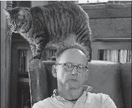  ?? DANA JENSEN/THE DAY ?? David Handler at home with his cat Leon in 2018.