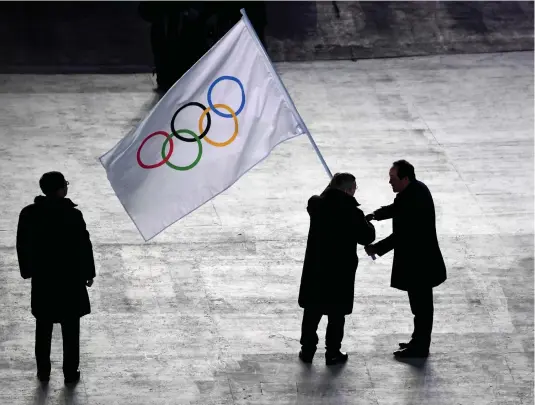  ??  ?? IOC President Thomas Bach (C) takes over the Olympic flag from Mayor of Pyeongchan­g Sim Jae-guk before handing it to Mayor of Beijing Chen Jining (R) during the closing ceremony of the Pyeongchan­g 2018 Winter Olympic Games. Games e-commerce sponsor...