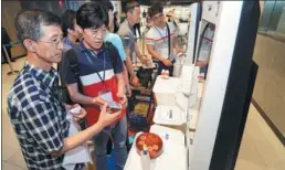  ?? PROVIDED TO CHINA DAILY ?? Tourists from South Korea use a self-service payment system at an Alibaba Hema Fresh food store in