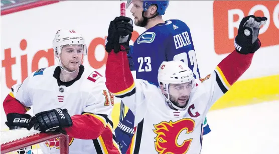  ?? JONATHAN HAYWARD/THE CANADIAN PRESS ?? Calgary defenceman Mark Giordano celebrates one of his two goals against the Vancouver Canucks in a 6-1 victory Sunday night in Vancouver.