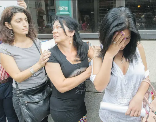  ?? PHIL CARPENTER ?? Hoda Asmar, left, of Solidarity Across Borders, comforts Katalin Lakatos and her daughter Gilda outside the Citizenshi­p and Immigratio­n Canada Office on St-Antoine St. on Thursday, after Katalin and Gilda learned the date of their deportatio­n.