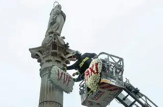  ?? (Bergamasch­i) ?? La cerimonia I vigili del fuoco appoggiano le tradiziona­li corone di fiori sulla statua della Madonna dei Noli