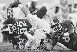  ??  ?? Penn State quarterbac­k Christian Hackenberg, center, is sacked by Michigan State’s Joel Heath (92) and Lawrence Thomas, right, during the second quarter of Saturday’s game.