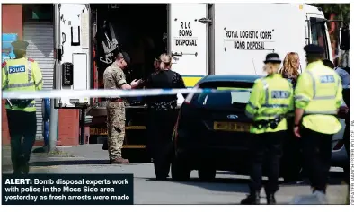  ??  ?? ALERT: Bomb disposal experts work with police in the Moss Side area yesterday as fresh arrests were made