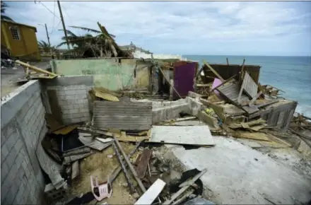  ?? CARLOS GIUSTI – THE ASSOCIATED PRESS ?? Debris lies on the ground Monday near several houses that were destroyed in the community of La Perla in Old San Juan during Hurricane Maria in San Juan, Puerto Rico. The island territory of more than 3 million U.S. citizens is reeling in the wake of...