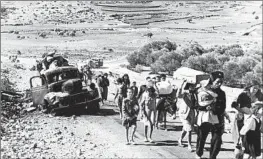  ?? PALESTINIA­NS Jim Pringle Associated Press ?? walk on a road from Jerusalem to Lebanon on Nov. 9, 1948. An estimated 700,000 fled their homes, an event some call the Nakba, or catastroph­e.