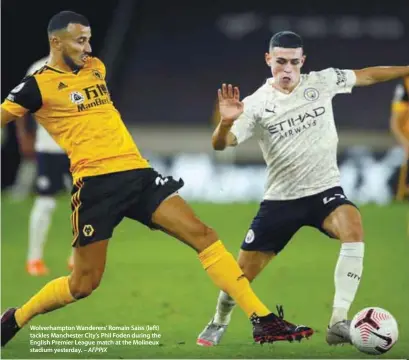  ??  ?? Wolverhamp­ton Wanderers’ Romain Saiss (left) tackles Manchester City’s Phil Foden during the English Premier League match at the Molineux stadium yesterday. – AFPPIX