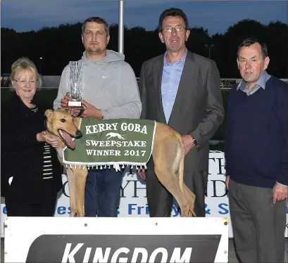  ??  ?? Teresa Holohan (K.G.O.B.A. Club Secretary ) presents the winner’s trophy to Marius Kybartas on behalf of the winning Smart Teacher Syndicate after Cash Is King won the K.G.O.B.A. Stakes Final for A7/A8 Greyhounds at the Kingdom Stadium on Saturday...