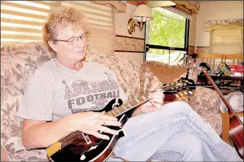  ?? TIMES photograph by Rachel Dickerson ?? Linda Luney of Pea Ridge plays the mandolin in her RV at the Lost Bridge North Park in Garfield.